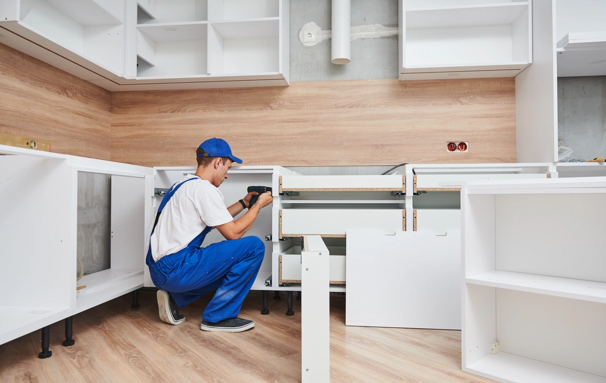 worker in the process of assembling kitchen cabinets